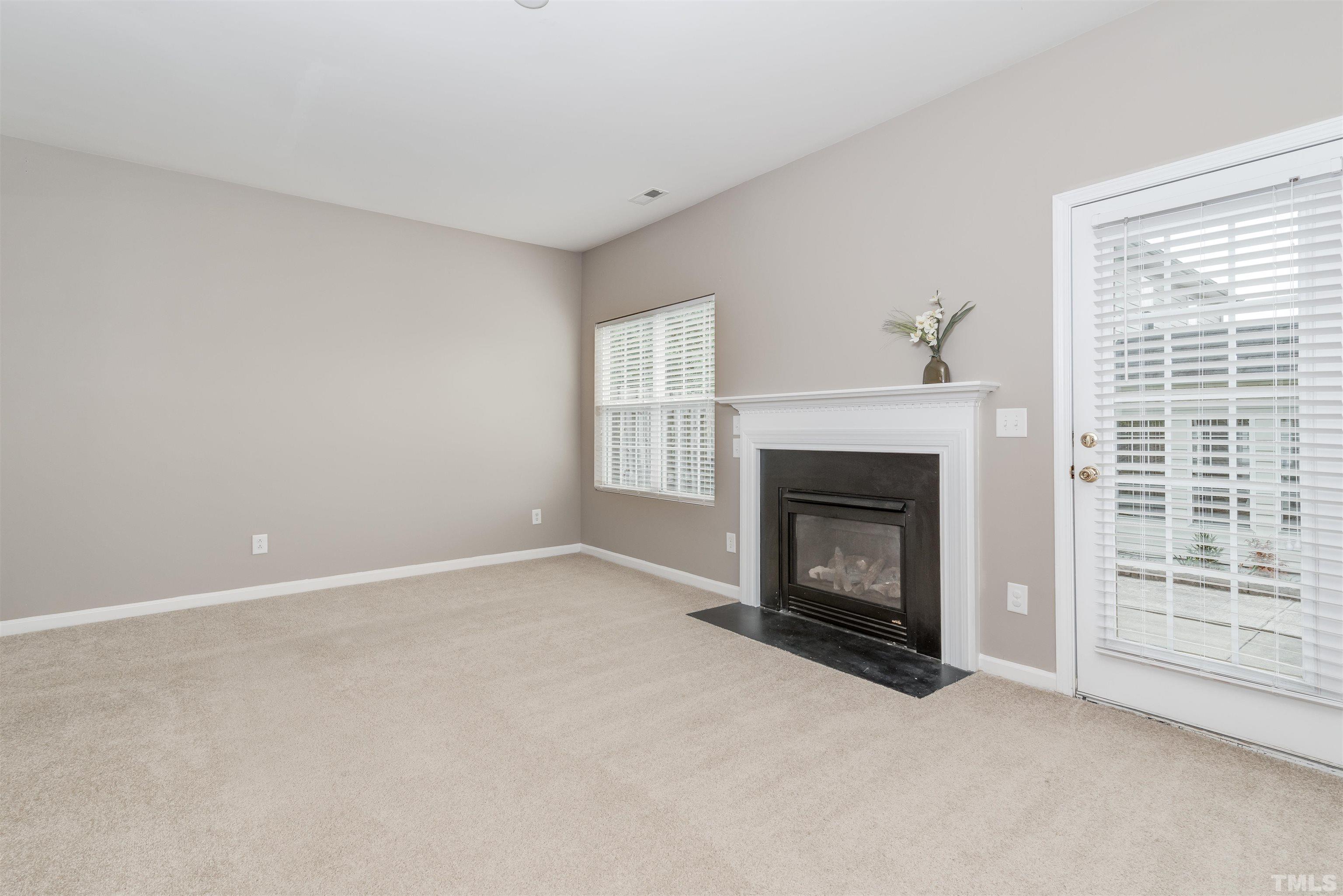 105 Graystar Road Apex, NC 27502 - Photo 7 of 35 a view of an empty room with a window and fireplace