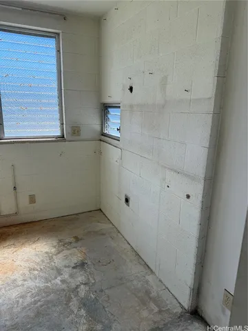 a view of cabinets and utility room with window