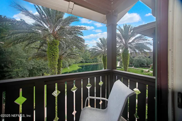 a view of a balcony with chairs and wooden fence