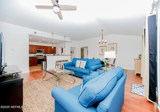 a living room with furniture kitchen view and a window