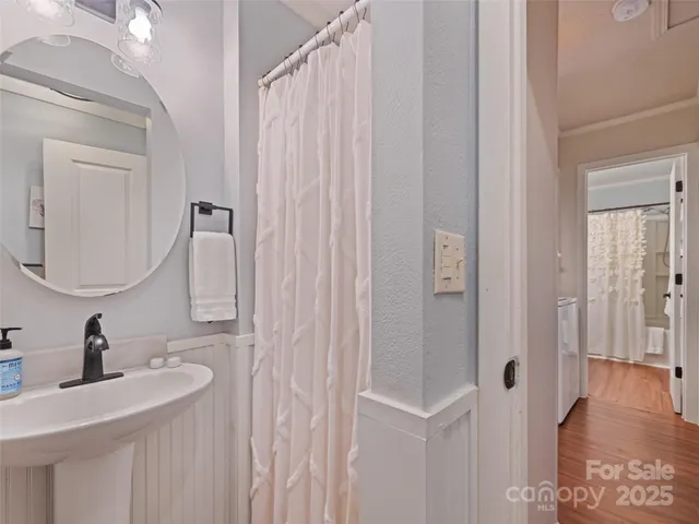a bathroom with a sink a toilet and shower curtain