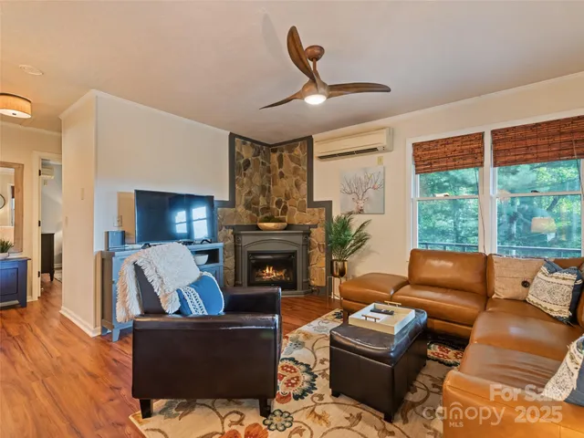 a living room with furniture fireplace and a large window