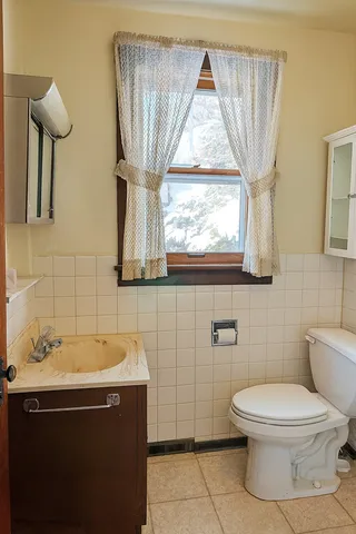 a bathroom with a toilet sink and mirror