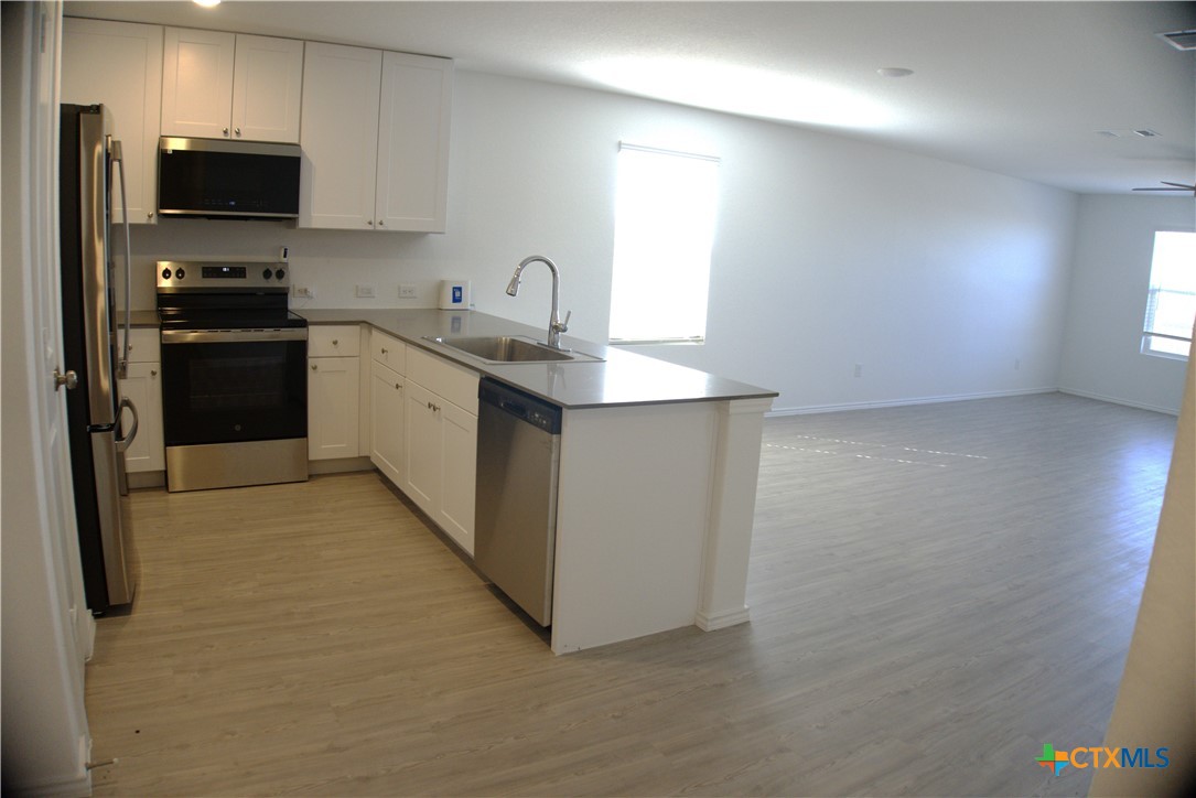809 Riviera Court Seguin, TX 78155 - Photo 2 of 8 a kitchen with stainless steel appliances a sink a stove a microwave a refrigerator a counter top space and cabinets