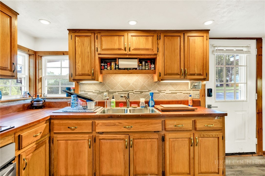 242 Ladd Parson Road Crumpler, NC 28617 - Photo 16 of 36 a kitchen with stainless steel appliances granite countertop a sink window and cabinets