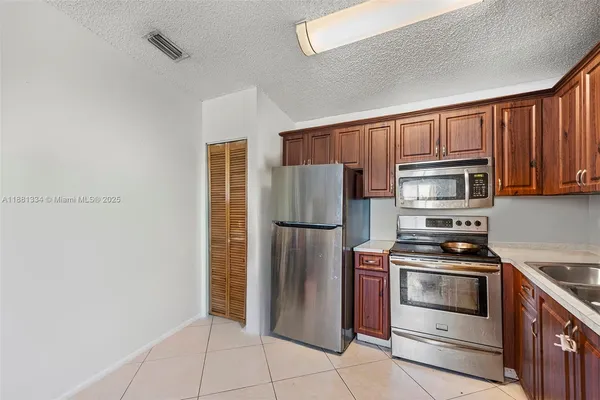 a kitchen with stainless steel appliances granite countertop a refrigerator stove and cabinets