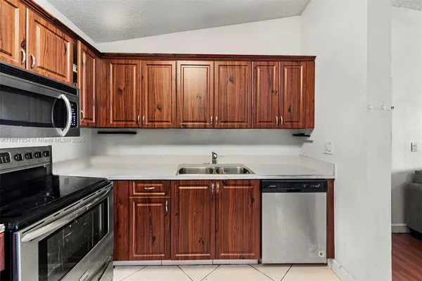 a kitchen with stainless steel appliances granite countertop a stove a microwave and a sink