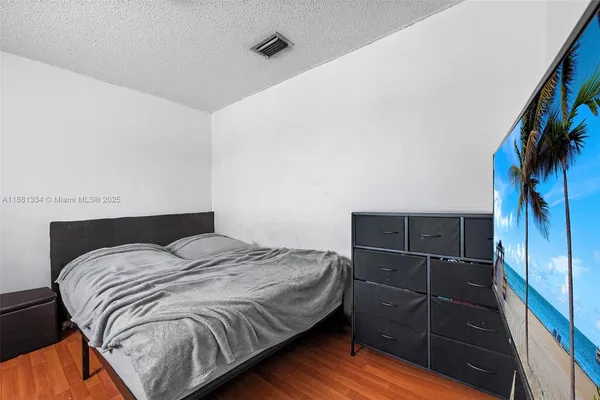 a bedroom with a bed and a flat tv screen on the wall