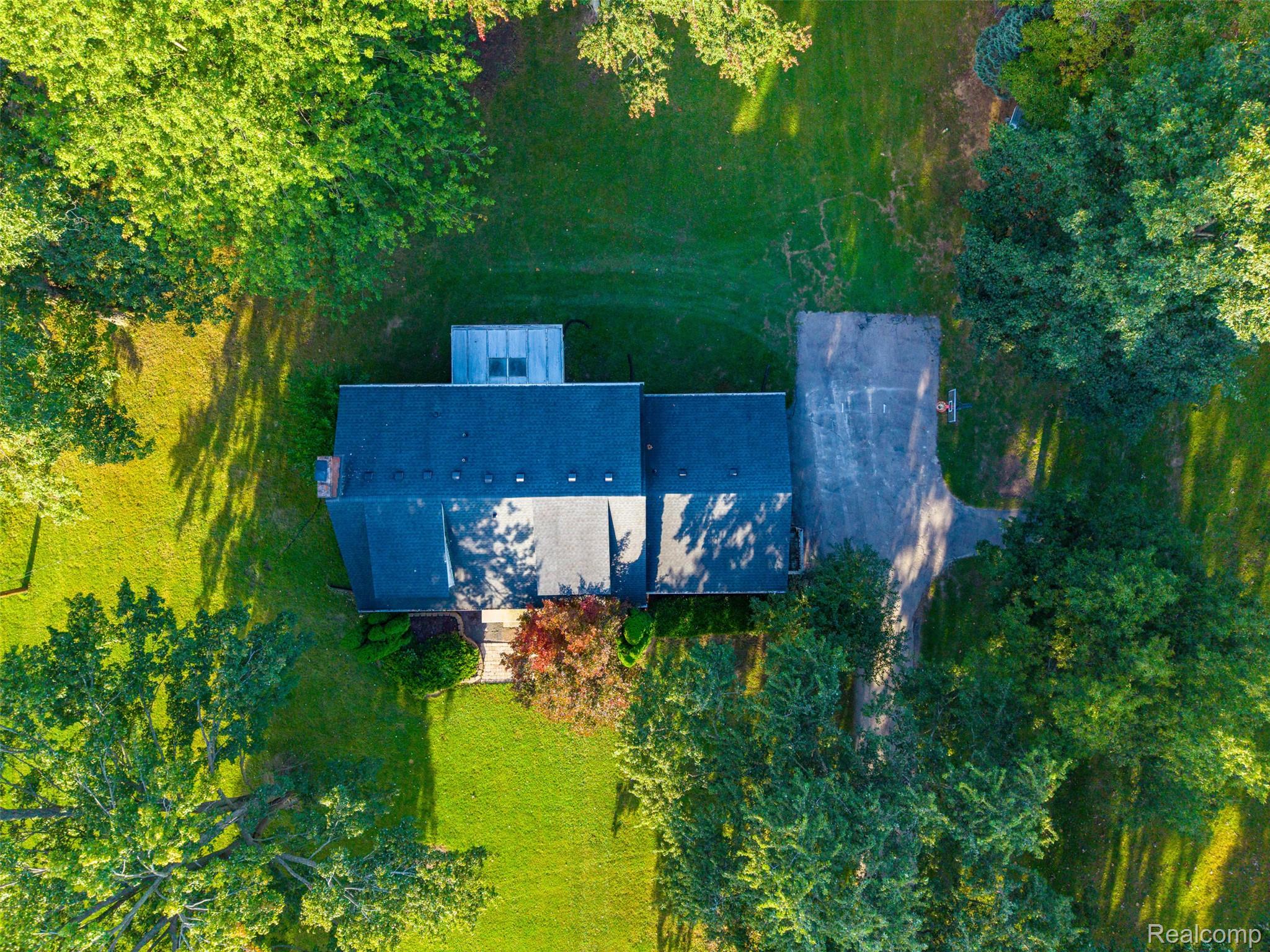26516 Romine Road New Boston, MI 48164 - Photo 50 of 62 Expansive lot with mature trees, a dark shingle roof, and a paved driveway