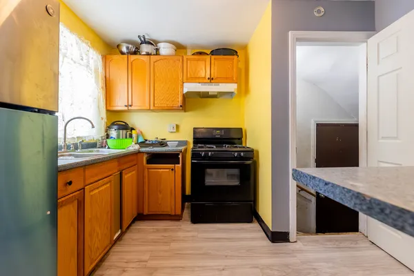 a kitchen with stainless steel appliances granite countertop a stove a sink and a refrigerator