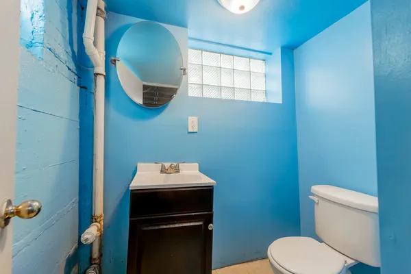 a bathroom with a toilet sink and mirror