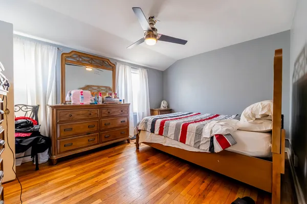 a bedroom with a bed and wooden floor