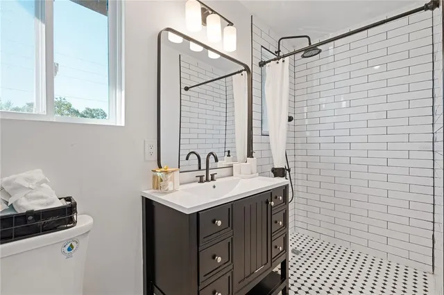 a bathroom with a sink a toilet and a mirror