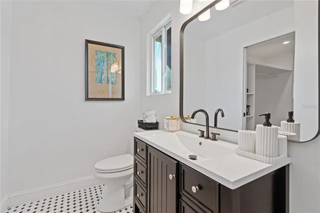 a bathroom with a sink a toilet and mirror
