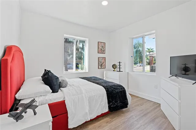 a bedroom with a bed and a flat tv screen on the dresser