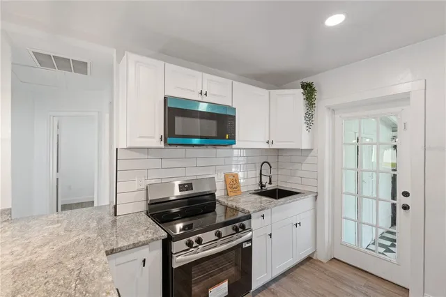 a kitchen with cabinets stainless steel appliances and a counter space