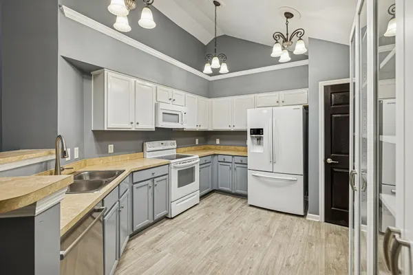 a kitchen with a refrigerator sink and cabinets
