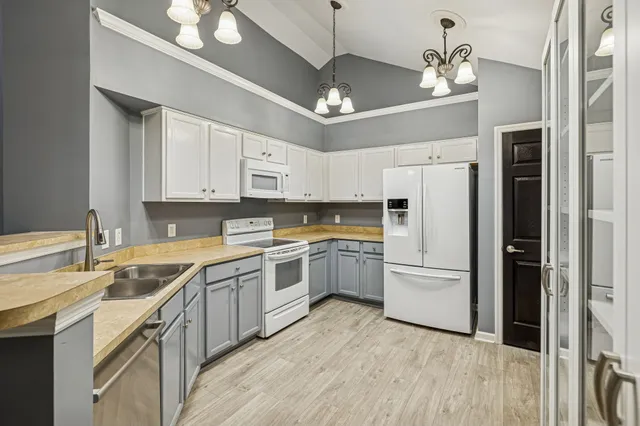 a kitchen with a refrigerator sink and cabinets
