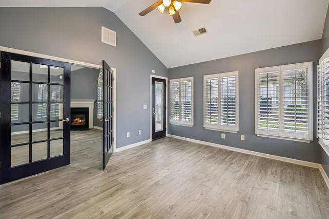 a view of an empty room with a window and wooden floor