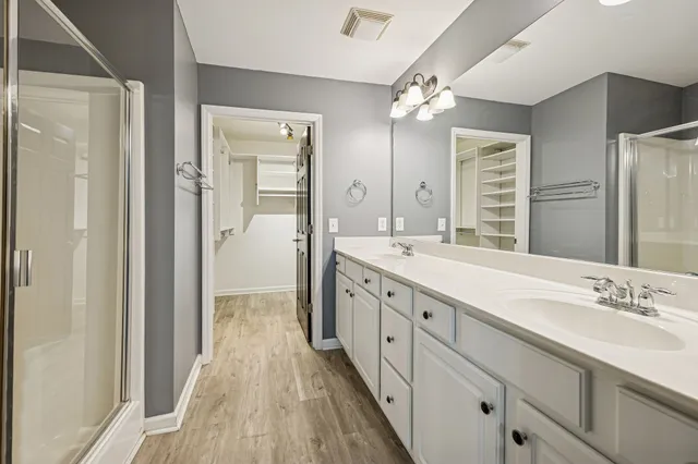 a spacious bathroom with a double vanity sink and mirror