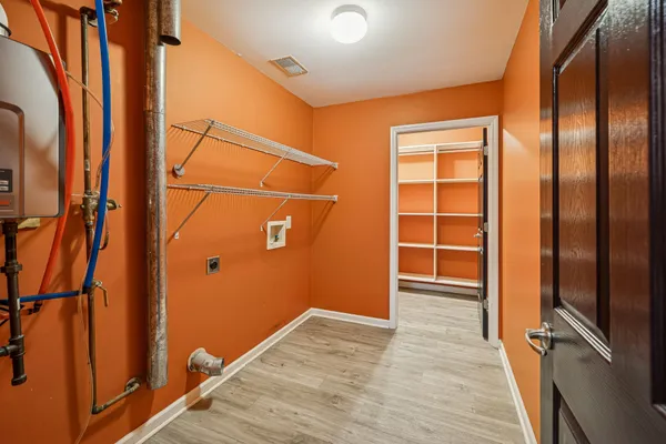 an empty room with wooden floor closet and windows