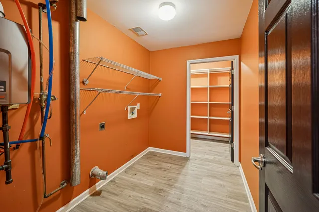 an empty room with wooden floor closet and windows