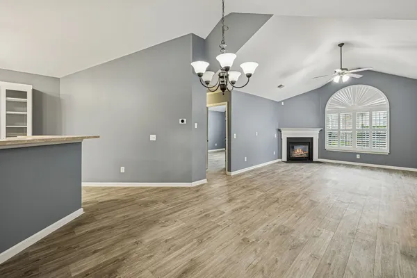 a view of an empty room with a fireplace and a window