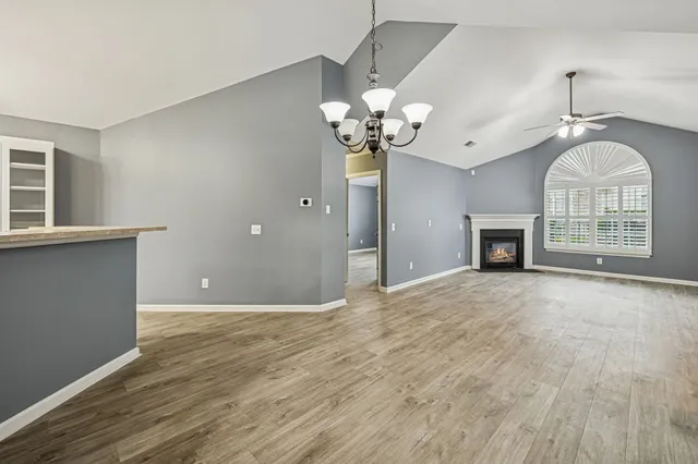 a view of an empty room with a fireplace and a window