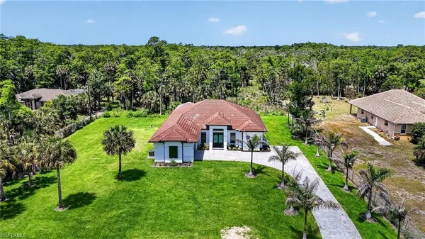 a aerial view of a house with swimming pool and green space
