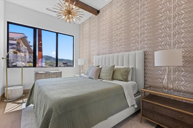 a view of an empty room with wooden floor and a flat screen tv