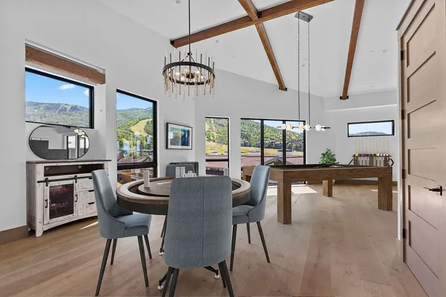 a dining room with furniture a floor to ceiling window and wooden floor
