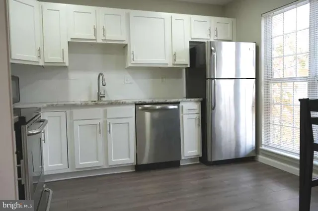 a kitchen with stainless steel appliances granite countertop a refrigerator sink and cabinets