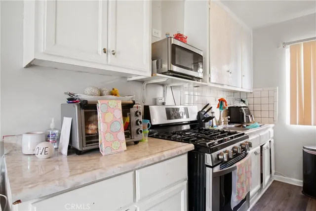 a kitchen with stainless steel appliances granite countertop a stove a microwave and cabinets