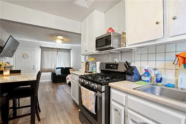 a kitchen with stainless steel appliances a stove a sink and a microwave