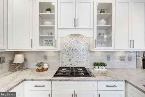 a kitchen with granite countertop stainless steel appliances white cabinets and a stove