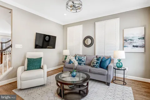 a living room with furniture a clock and a flat screen tv