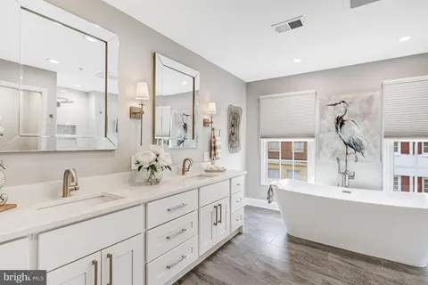 a bathroom with double vanity sinks a large mirror and a shower
