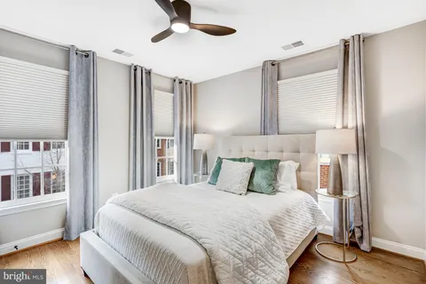 a bedroom with a large bed and wooden floor