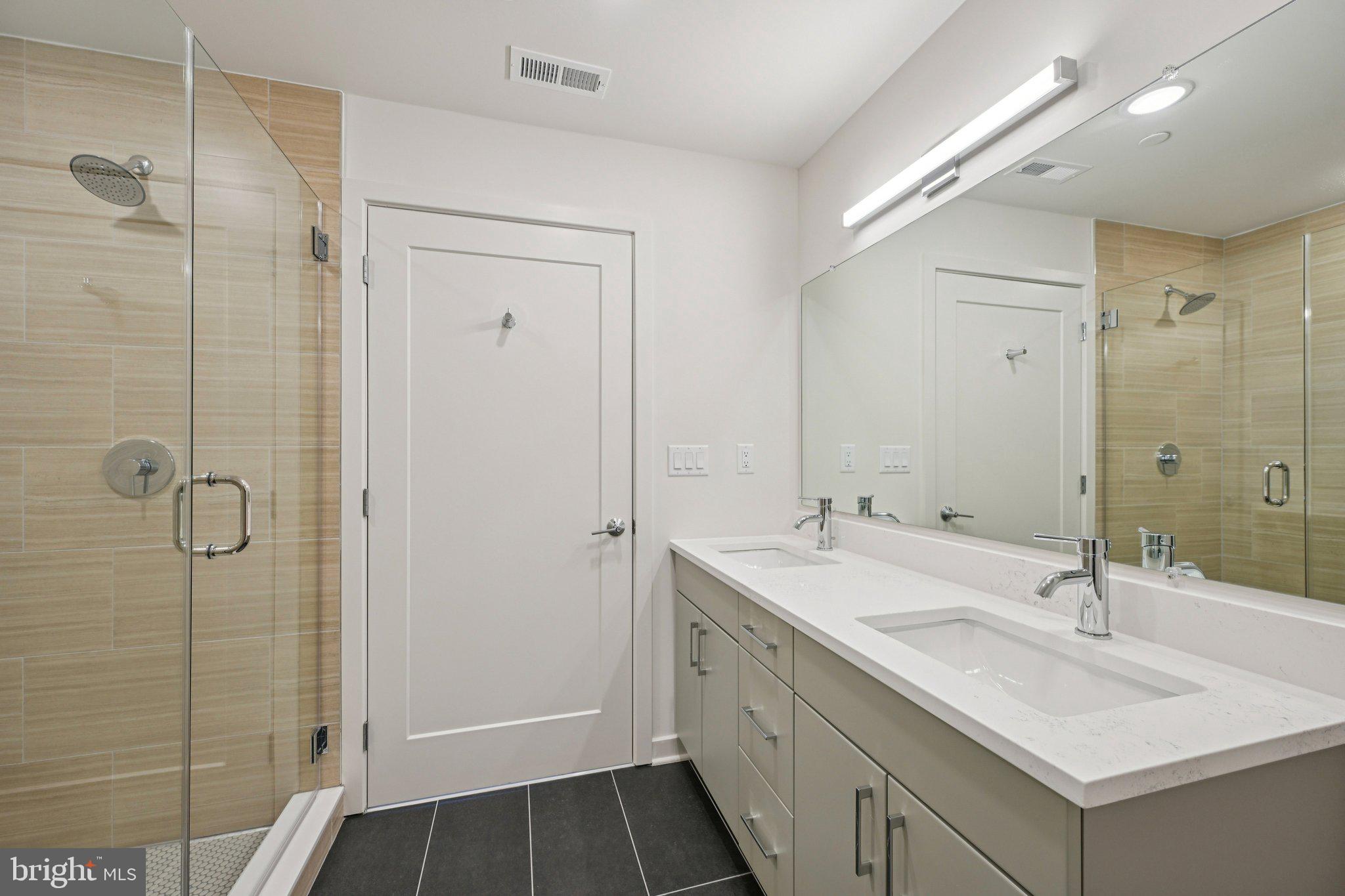23 Rock Hill Road, Unit 210 Bala Cynwyd, PA 19004 - Photo 7 of 7 a bathroom with a double vanity sink mirror and shower