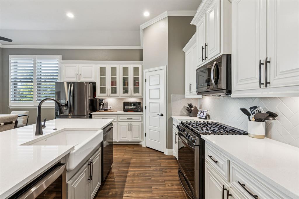 2925 Inn Kitchen Way McKinney, TX 75071 - Photo 9 of 40 a kitchen with stainless steel appliances a sink stove and refrigerator