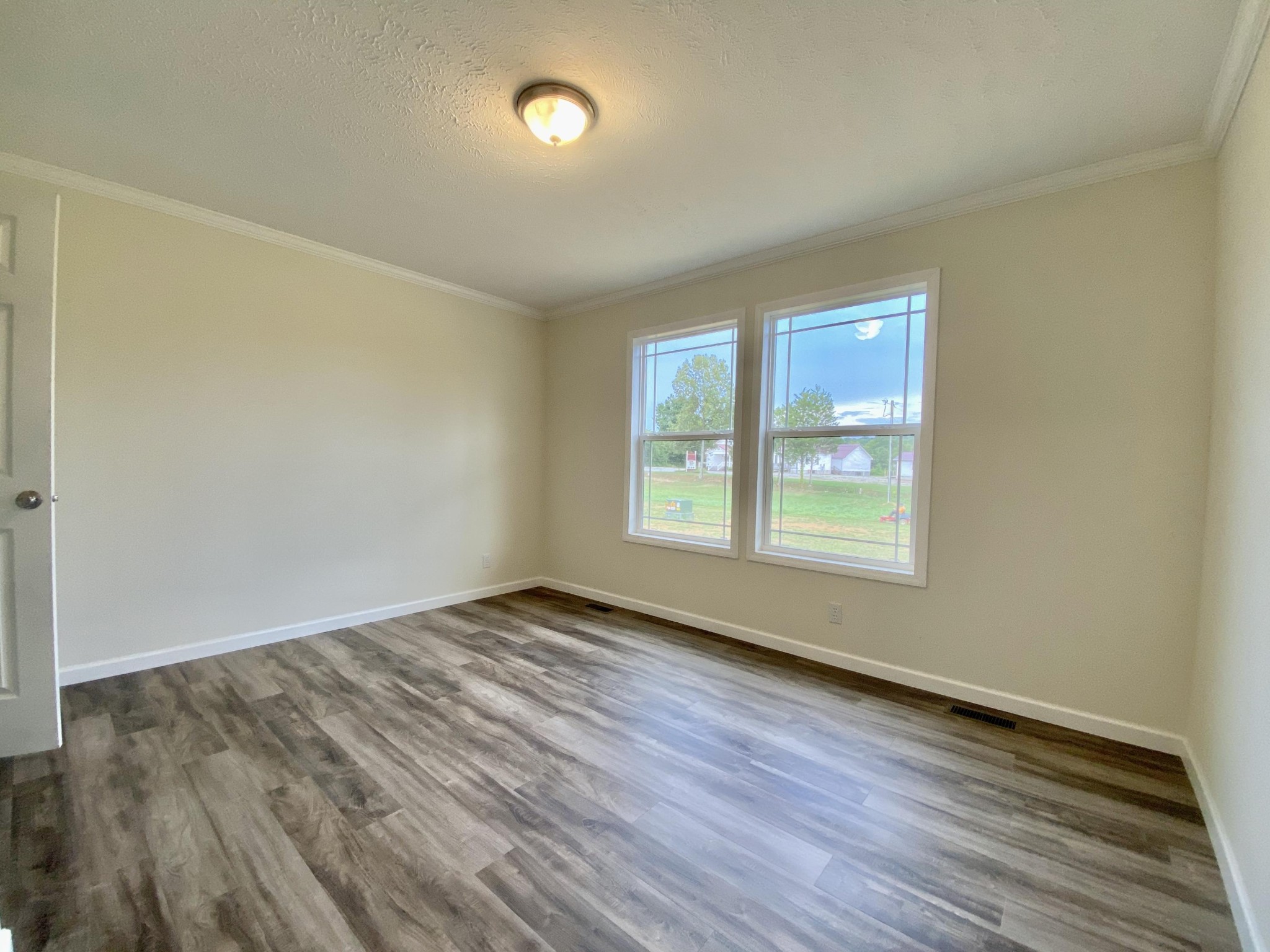 234 Walnut Grove Road Vonore, TN 37885 - Photo 16 of 26 an empty room with wooden floor and windows