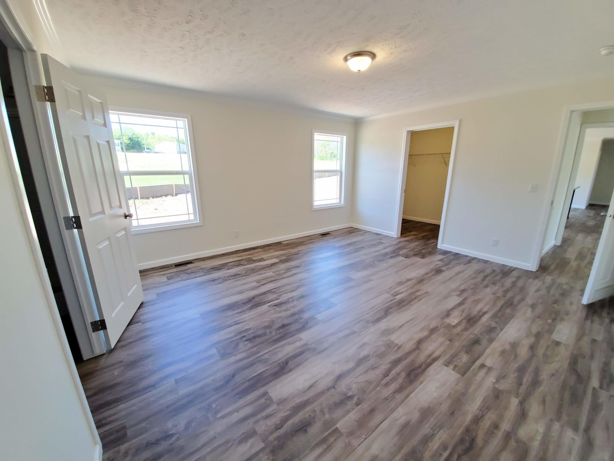 234 Walnut Grove Road Vonore, TN 37885 - Photo 9 of 26 an empty room with wooden floor and windows