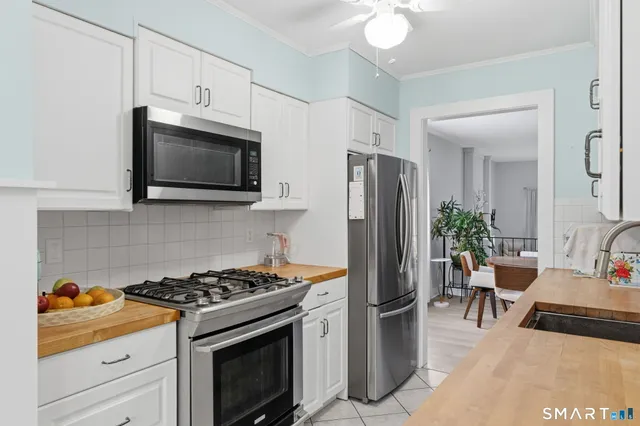 a kitchen with stainless steel appliances a stove microwave and refrigerator