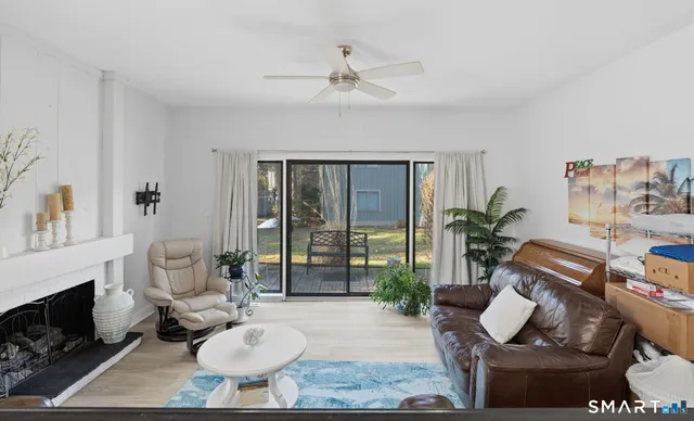 a living room with furniture a fireplace and a potted plant