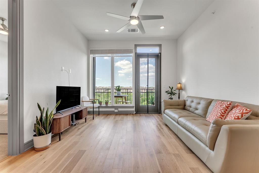 2700 Old Denton Road, Unit 4424 Carrollton, TX 75007 - Photo 2 of 12 a living room with furniture flat screen tv and wooden floor