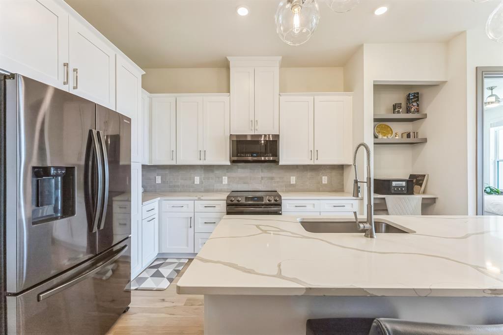 2700 Old Denton Road, Unit 4424 Carrollton, TX 75007 - Photo 3 of 12 a kitchen with stainless steel appliances kitchen island granite countertop a refrigerator a stove and a sink