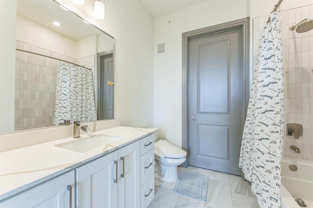 2700 Old Denton Road, Unit 4424 Carrollton, TX 75007 - Photo 9 of 12 a bathroom with a granite countertop sink a toilet a mirror a vanity and shower