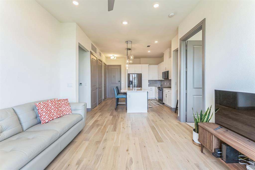 2700 Old Denton Road, Unit 4424 Carrollton, TX 75007 - Photo 10 of 12 a living room with furniture and a wooden floor