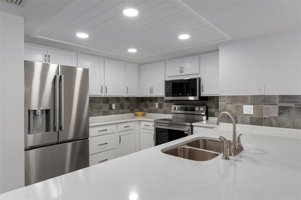 3 Cypress Run, Unit 33A Homosassa, FL 34446 - Photo 5 of 54 a kitchen with stainless steel appliances granite countertop a refrigerator a sink a stove a microwave and a refrigerator with wooden floor