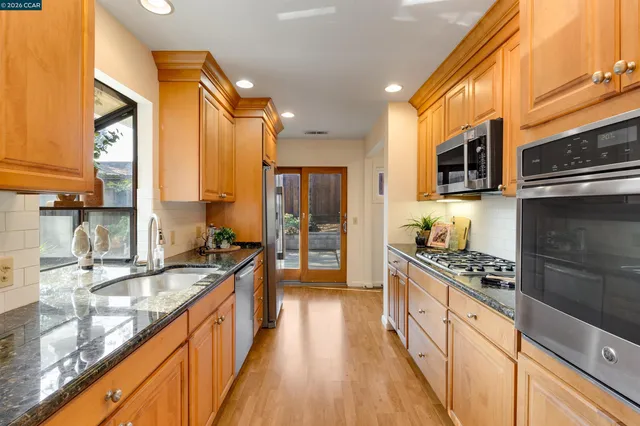a kitchen with stainless steel appliances kitchen island granite countertop a stove and a microwave